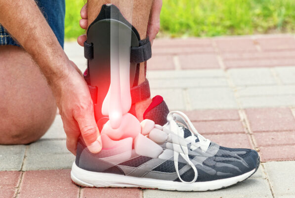 Man in athletic sneakers checking his ankle orthosis or brace on the street