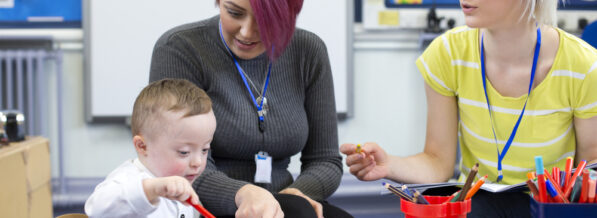 Nursery,Teacher,Sitting,With,A,Parent,And,Her,Down,Syndrome